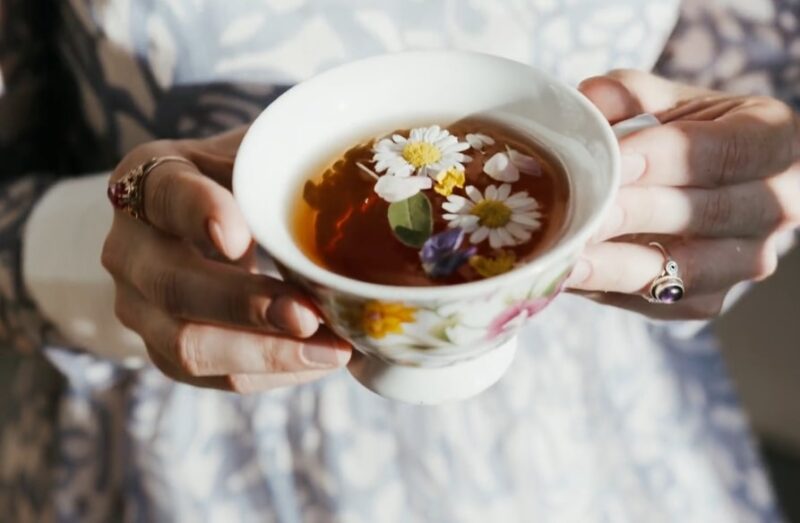 The woman is drinking chamomile tea known for its calming effects